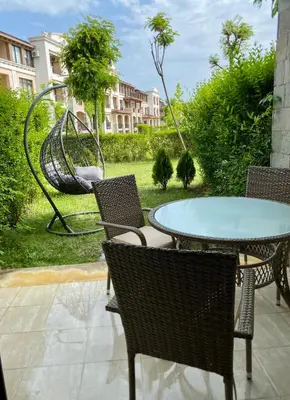 a patio with a table and chairs and a swing at Green life private garden studio in Sozopol