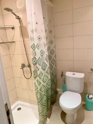 a bathroom with a toilet and a shower curtain at Green life private garden studio in Sozopol