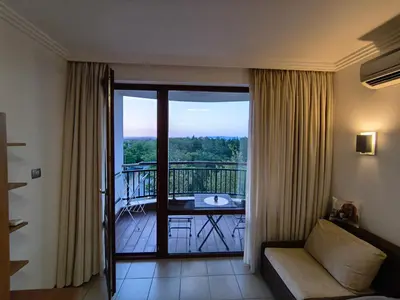 a living room with a view of a balcony at Emerald Apartman Wellness & Spa in Ravda