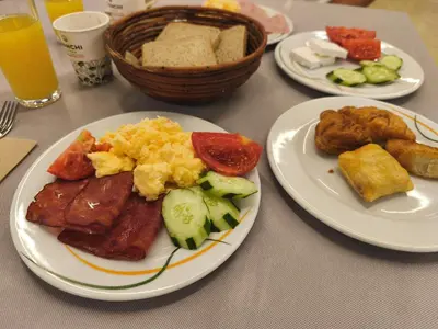 a table with plates of breakfast food on it at Emerald Apartman Wellness & Spa in Ravda
