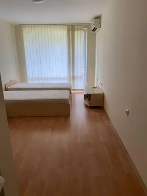 a bedroom with a bed and a wooden floor at Studio near the center in Sunny Beach
