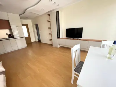 an empty living room with a table and a tv at 2BR Garden Bay Apartment in Varna City