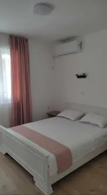 a bedroom with a white bed with a window at Relax in Tsarevo
