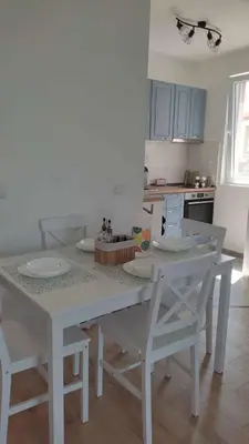 a kitchen with a white table and chairs in a room at Relax in Tsarevo