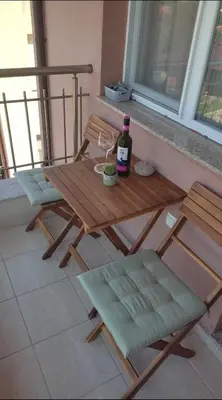 a picnic table with a bottle of wine and two chairs at Relax in Tsarevo