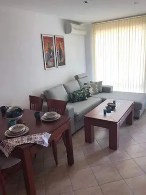 a living room with a couch and two tables at The white flat in Byala