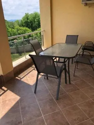 a patio with a table and chairs and a balcony at The white flat in Byala