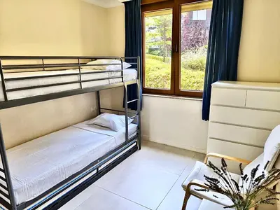two bunk beds in a room with a window at Cozy Ground-Floor Apartment with Terrace in Sozopol