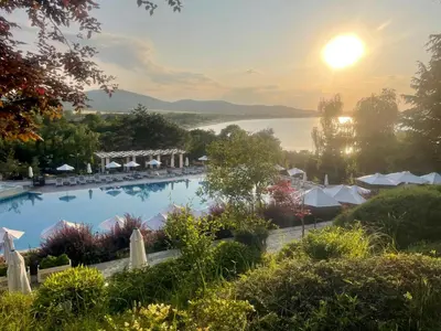 a view of the pool at the inn on the lake at sunset at Cozy Ground-Floor Apartment with Terrace in Sozopol