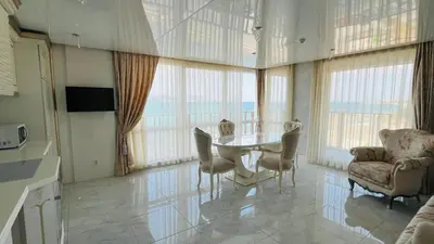a dining room with a table and chairs and windows at PARADADISO B 307 Two Bedroom Sea View Apartment in Nesebar