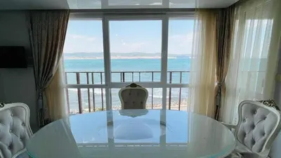 a glass table and chairs in front of a large window at PARADADISO B 307 Two Bedroom Sea View Apartment in Nesebar