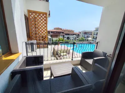 a balcony with a view of a swimming pool at Апартамент в Комплекс Райска градина in Sveti Vlas