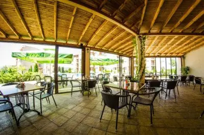a restaurant with tables and chairs in a room at Nesebar - Orchid 278 in Sunny Beach