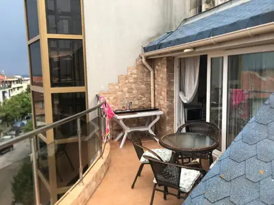 a balcony with a table and chairs on a building at Terasa Ravda apart in Ravda