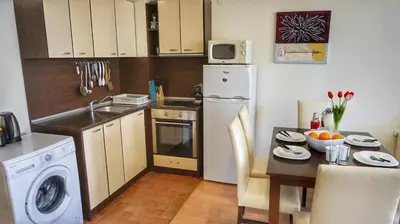 a small kitchen with a table and a sink and a refrigerator at Two bedroom Apartment in Fort Noks Panorama beach in Elenite