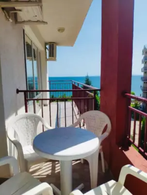 a table and chairs on a balcony with the ocean at Two bedroom Apartment in Fort Noks Panorama beach in Elenite