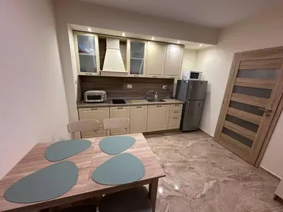 a kitchen with a wooden table and a refrigerator at Sunrise Apartment in Pomorie