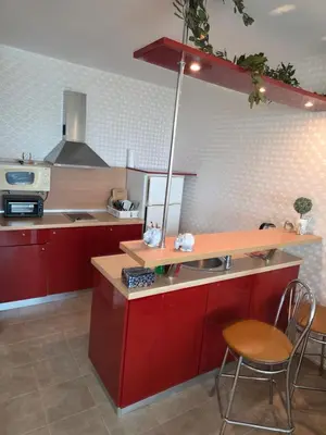 a kitchen with red cabinets and a table and chairs at Apartment Miramar Palace in Sunny Beach