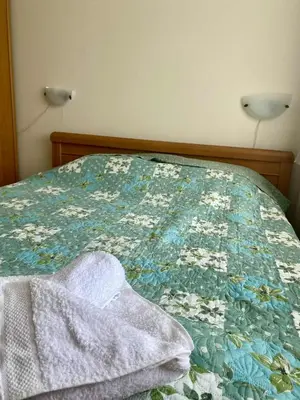 a bed with a blue and white quilt on it at Peaceful, Top Floor, 2 Bedroom in Sunny Beach