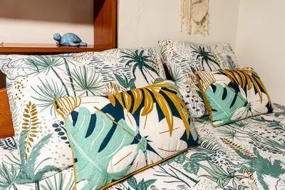 a couch with tropical pillows on top of it at Afala Loft & Terrase - Heart of Burgas in Burgas City