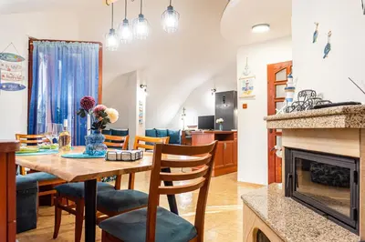 a dining room and living room with a table and a fireplace at Afala Loft & Terrase - Heart of Burgas in Burgas City