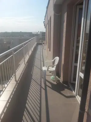 a balcony with a white chair on a building at Anfid Apartments in Burgas City
