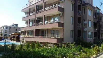 a tall apartment building with a pool in front of it at Anfid Apartments in Burgas City