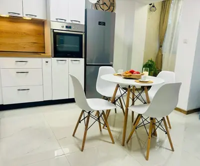 a kitchen with a table and chairs with a bowl of fruit on it at Sea Breeze in Burgas City