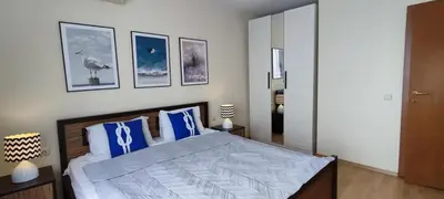 a bedroom with a large bed with blue pillows at Imperial Sea View in Burgas City