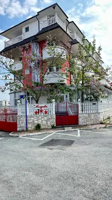 a building with a red and white fence in front of it at Хотел Модева in Chernomorets