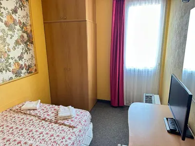 a bedroom with a bed and a desk with a computer at Хотел Модева in Chernomorets