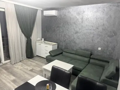 a living room with a green couch and a table at Апартамент Велкови in Tsarevo