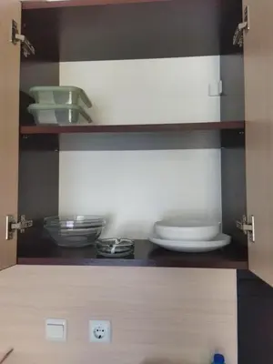 a cupboard with plates and bowls in a kitchen at Святая Елена in Sunny Beach