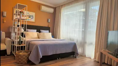 a bedroom with a bed and a window and a tv at Emerald Breeze Studio in Hotel SPA Resort Emerald in Ravda