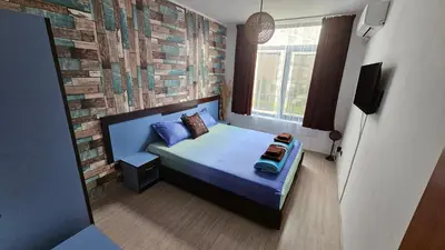 a bedroom with a bed and a brick wall at Apartment 16 - Rainbow Holiday Complex in Sunny Beach