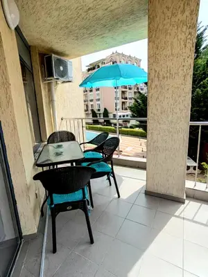 a patio with a table and chairs and an umbrella at Apartment 16 - Rainbow Holiday Complex in Sunny Beach
