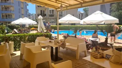 a patio with tables and chairs and a pool at Apartment 16 - Rainbow Holiday Complex in Sunny Beach