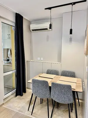 a dining room with a table and chairs at Beach Please Apartment in Burgas City