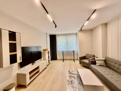 a living room with a couch and a flat screen tv at Beach Please Apartment in Burgas City
