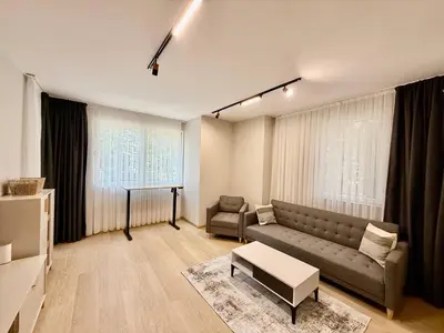 a living room with a couch and a table at Beach Please Apartment in Burgas City