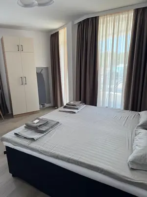 a large bed in a room with a large window at Апартаменти в Созопол, Каваци- Север in Sozopol