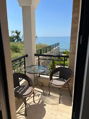 a balcony with a table and chairs and the ocean at Onyx Sveti Vlas частни апартаменти in Sveti Vlas