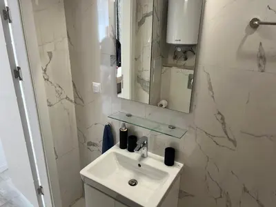 a white bathroom with a sink and a mirror at Onyx Sveti Vlas частни апартаменти in Sveti Vlas