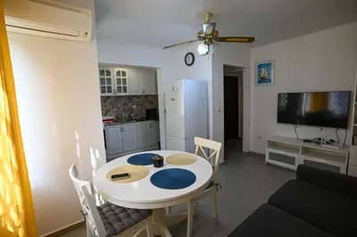 a kitchen with a white table and a white refrigerator at Уют и тишина на топ локация in Varna City