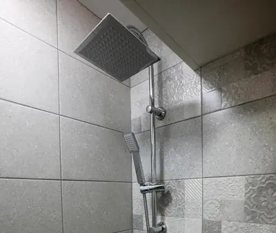 a shower with a shower head in a bathroom at Уют и тишина на топ локация in Varna City