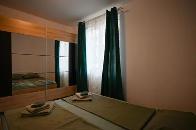 a bedroom with a bed with green curtains and a mirror at Уют и тишина на топ локация in Varna City