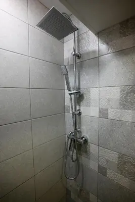 a shower with a shower head in a bathroom at Уют и тишина на топ локация in Varna City