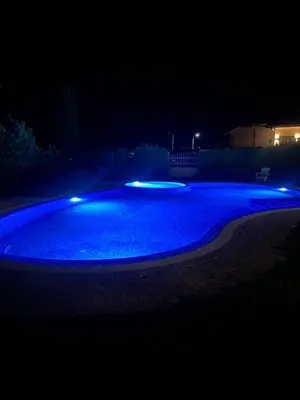 a large swimming pool lit up at night at Sea View Apartment in Byala in Byala