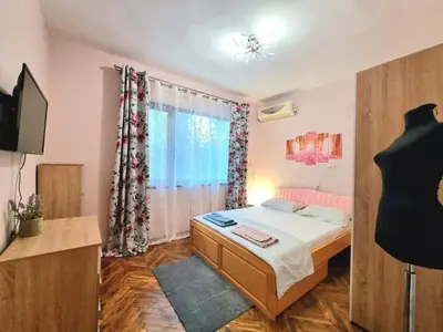 a small bedroom with a bed and a window at Nicky's Apartment - with Private Parking in Center in Burgas City
