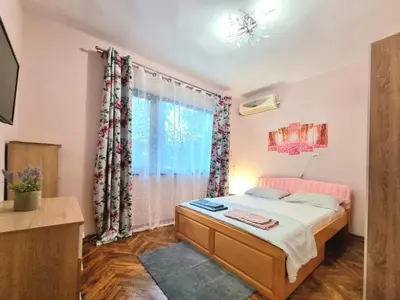 a bedroom with a bed and a window at Nicky's Apartment - with Private Parking in Center in Burgas City